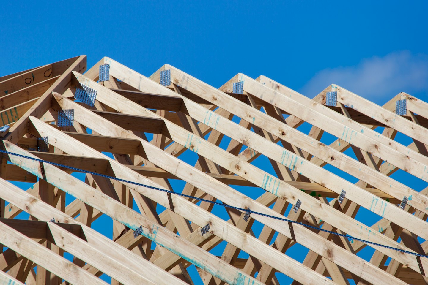 Wooden roof trusses form the skeleton of a building under construction.